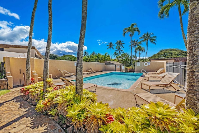 community pool featuring a patio and fence