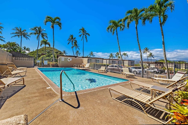 pool with a patio area and fence