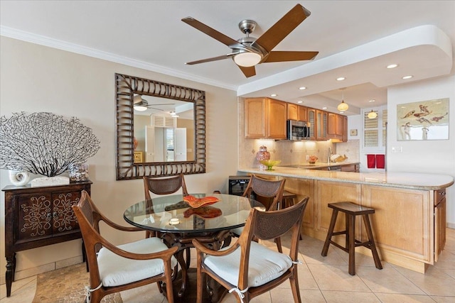 tiled dining space with ornamental molding and ceiling fan