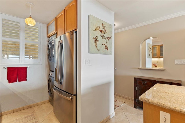 kitchen with light tile floors, stacked washer and dryer, stainless steel refrigerator with ice dispenser, and pendant lighting