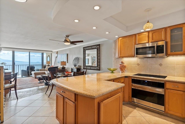 kitchen with pendant lighting, ceiling fan, crown molding, stainless steel appliances, and tasteful backsplash