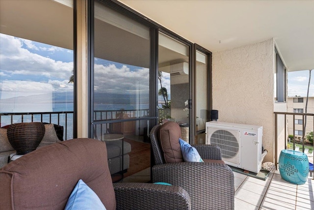 balcony with a water view and a wall mounted air conditioner