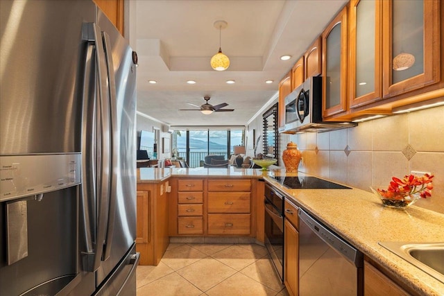 kitchen with appliances with stainless steel finishes, light stone counters, tasteful backsplash, pendant lighting, and ceiling fan