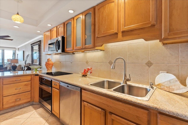 kitchen with tasteful backsplash, hanging light fixtures, appliances with stainless steel finishes, and sink