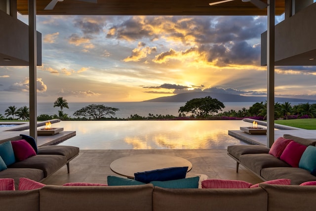 patio terrace at dusk with ceiling fan and a water view