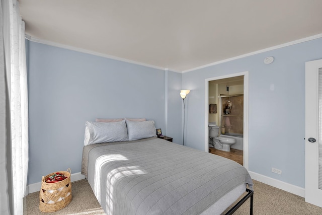 bedroom with carpet floors, crown molding, and ensuite bath