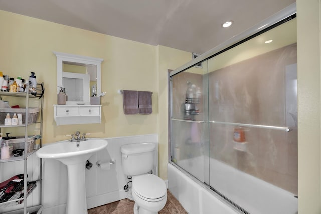 full bathroom featuring toilet, enclosed tub / shower combo, and sink