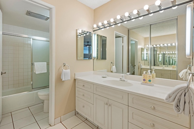 bathroom featuring shower / bath combination with glass door, visible vents, toilet, tile patterned floors, and vanity