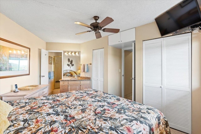 bedroom featuring a textured ceiling, ceiling fan, and multiple closets