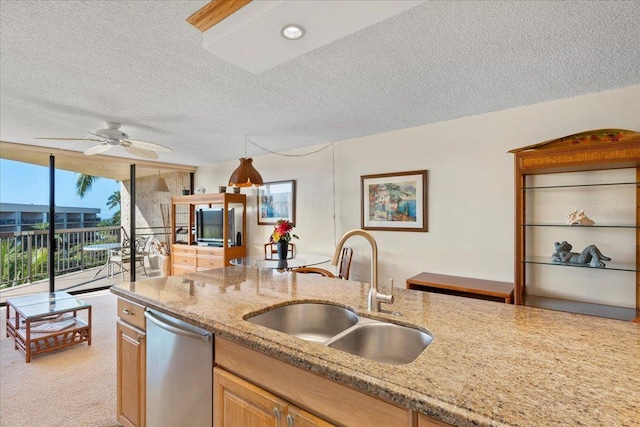 kitchen with stainless steel dishwasher, ceiling fan, light stone countertops, and sink