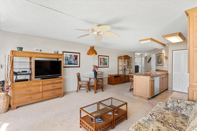 carpeted living room featuring a textured ceiling, ceiling fan, and sink