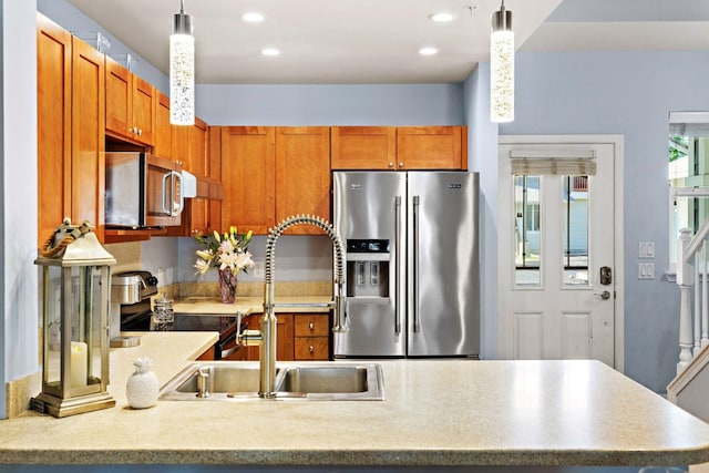 kitchen featuring sink, decorative light fixtures, and appliances with stainless steel finishes