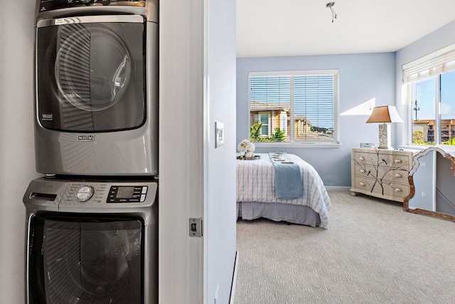 carpeted bedroom featuring stacked washer / drying machine and multiple windows