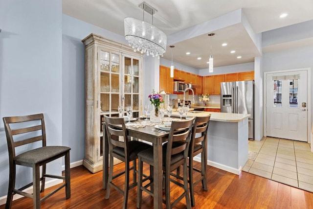 dining space featuring light hardwood / wood-style flooring and a notable chandelier