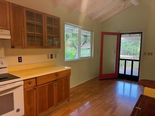 kitchen with white range with electric cooktop, light wood-type flooring, and vaulted ceiling with beams