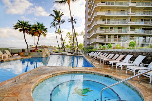 view of swimming pool with a patio area and a hot tub