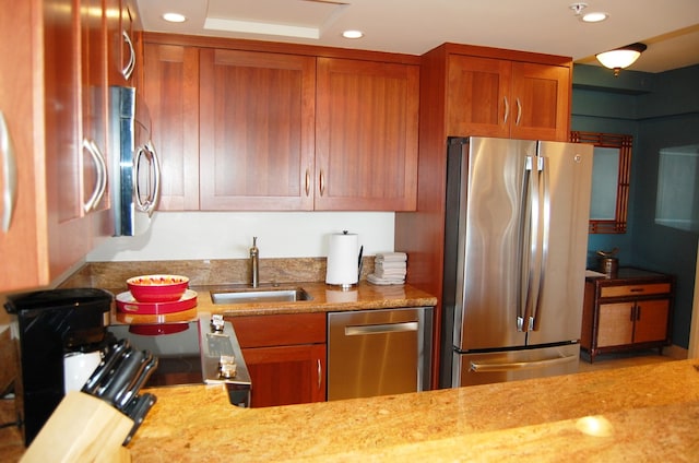 kitchen with sink, stainless steel appliances, and light stone counters