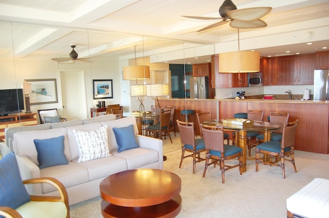 carpeted living room featuring sink, beamed ceiling, and ceiling fan