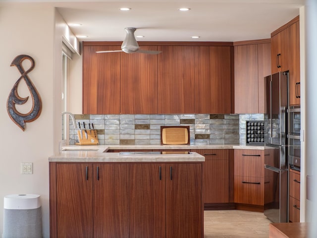 kitchen with stainless steel oven, cooktop, decorative backsplash, and sink