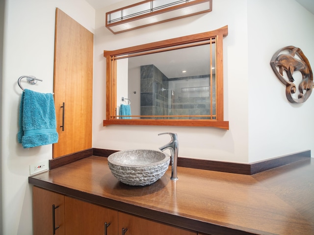 bathroom featuring a tile shower and vanity