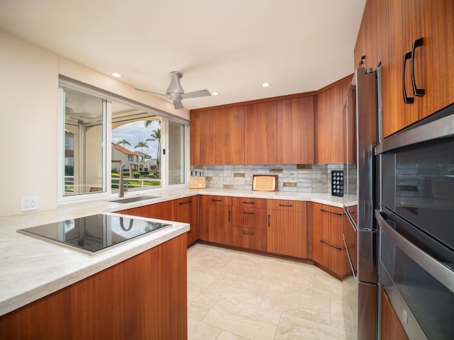 kitchen with sink, ceiling fan, tasteful backsplash, black electric cooktop, and double oven