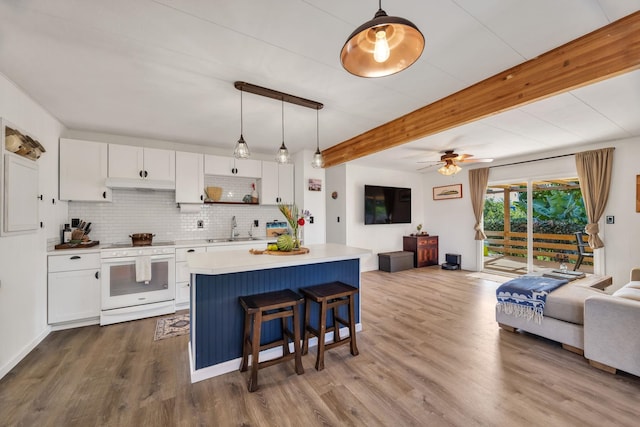 5131 Hanawai St Unit F, Lahaina, HI 96761 - kitchen with white stove, open floor plan, under cabinet range hood, a sink, and white cabinetry