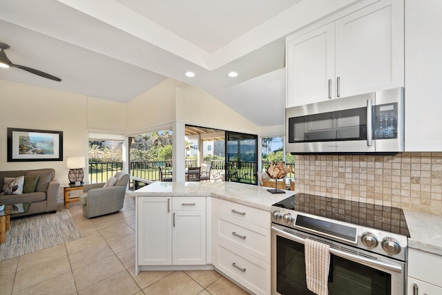 kitchen with appliances with stainless steel finishes, light tile patterned floors, white cabinetry, and light stone counters