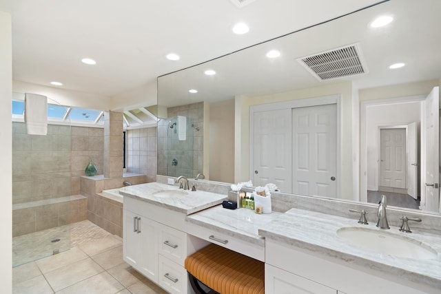 bathroom with tile patterned floors, vanity, and a tile shower