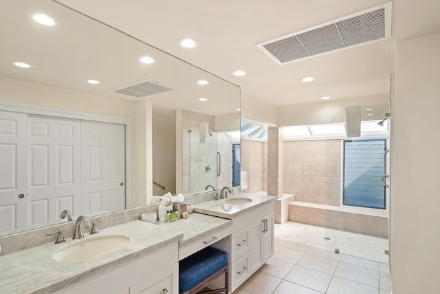 bathroom featuring tile patterned floors, vanity, and a tile shower