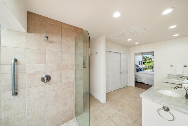 bathroom with tile patterned flooring, vanity, and tiled shower