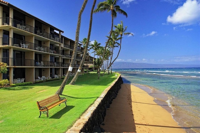 view of home's community featuring a view of the beach, a water view, and a yard