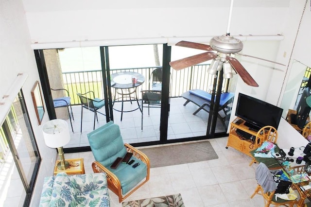 living area featuring a ceiling fan and tile patterned flooring