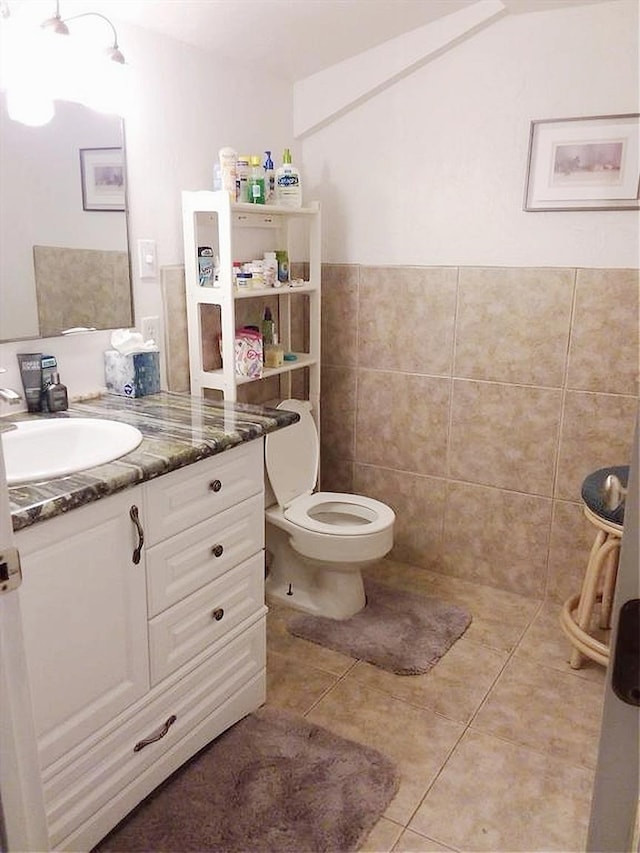 bathroom featuring toilet, tile walls, vanity, and tile patterned floors