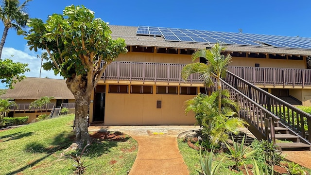 view of front of property with a front yard and solar panels