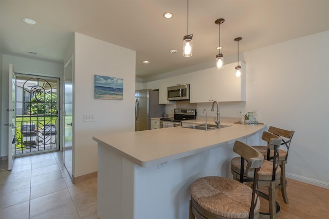 43 Polohina Ln Unit 13-8, Lahaina, HI 96761 - kitchen featuring stainless steel appliances, a peninsula, a breakfast bar, light countertops, and white cabinetry