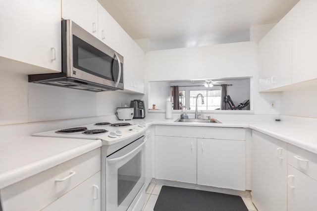 kitchen featuring white cabinets, white range with electric cooktop, sink, and light tile patterned floors