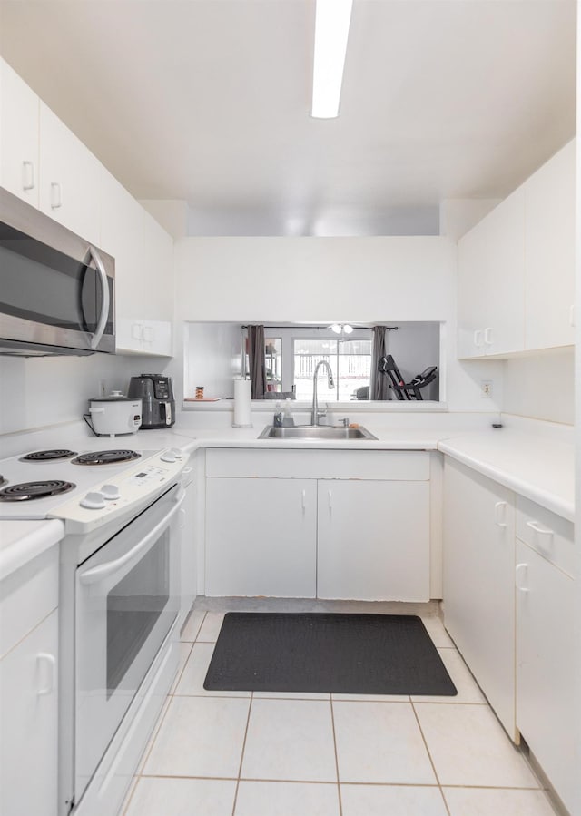 kitchen featuring white cabinetry, sink, white range with electric stovetop, and light tile patterned floors