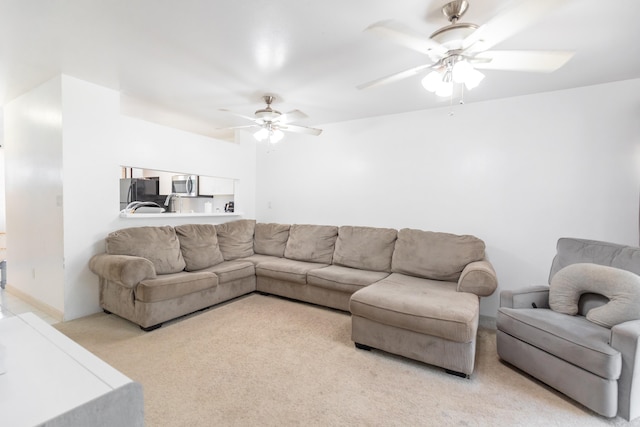 carpeted living room featuring ceiling fan