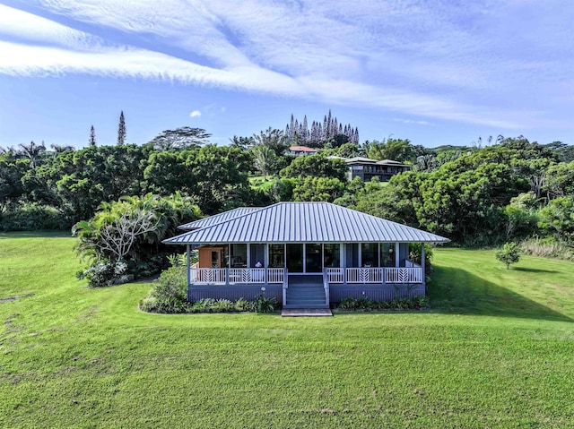 view of front of property featuring metal roof, a porch, and a front yard