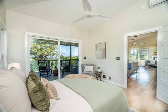 bedroom featuring a wall mounted air conditioner, light wood finished floors, baseboards, access to outside, and lofted ceiling