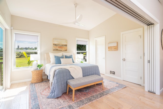 bedroom featuring baseboards, light wood-type flooring, and lofted ceiling