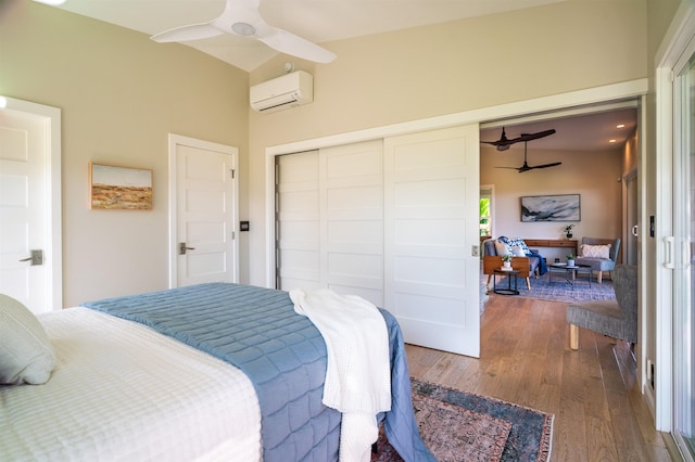 bedroom with a closet, wood finished floors, and an AC wall unit
