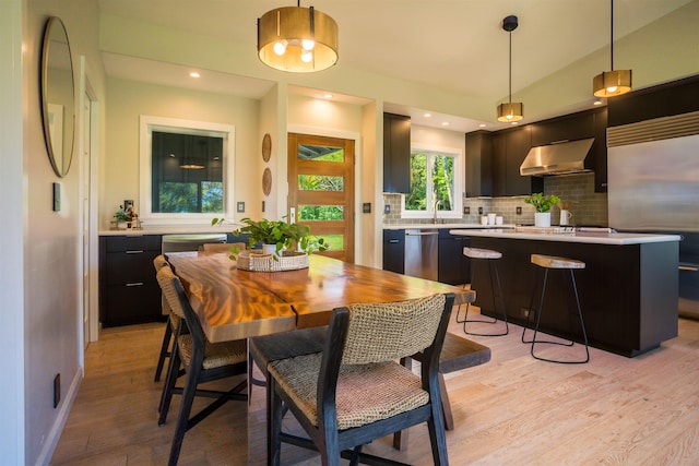 dining area featuring baseboards, lofted ceiling, light wood finished floors, and recessed lighting