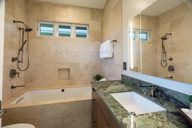 bathroom with toilet, tiled shower / bath, and vanity