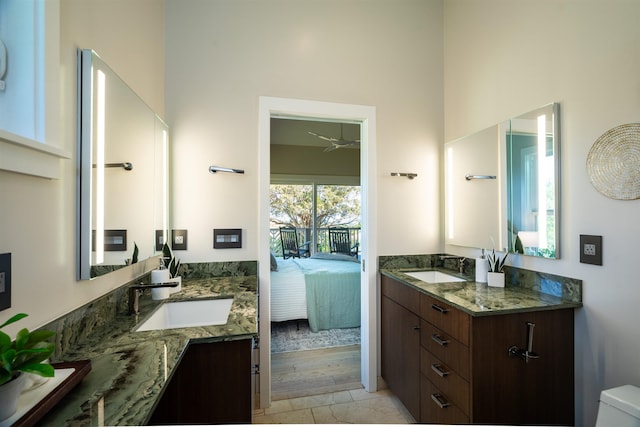 bathroom featuring ensuite bathroom, ceiling fan, a sink, and two vanities