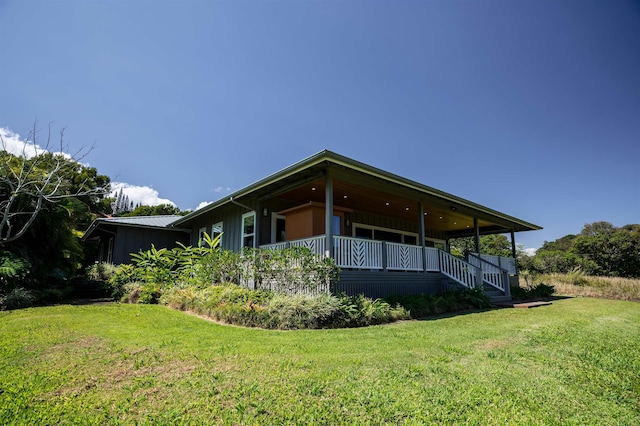 rear view of property featuring a lawn and board and batten siding