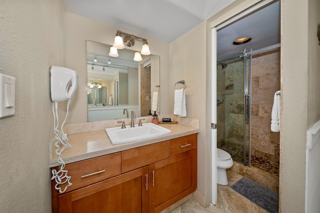 bathroom featuring a shower with door, tile flooring, toilet, and vanity