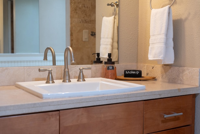 bathroom with vanity with extensive cabinet space and tasteful backsplash