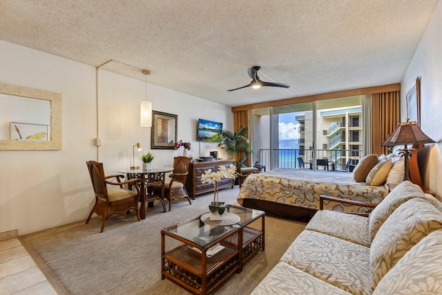 4365 Lower Honoapiilani Rd Unit 603, Lahaina, HI 96761 - tiled bedroom with access to exterior, a wall of windows, a textured ceiling, carpet floors, and a ceiling fan