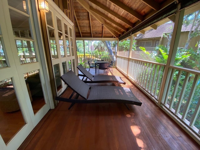 sunroom with wooden ceiling, a healthy amount of sunlight, and lofted ceiling with beams